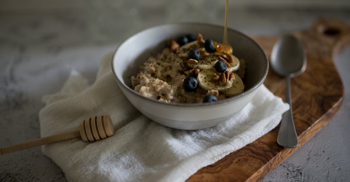 A delicious and nutritious oatmeal bowl with bananas, blueberries, walnuts, and honey.